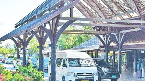 Arrival area at Koh Samui airport with a transfer minibus