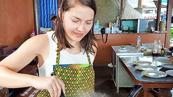 Participant cooking with a wok at a Thai cooking class on Koh Samui