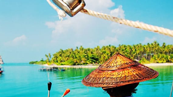 Captain at the helm of a sailing boat in the sunshine near an island off Koh Samui in June
