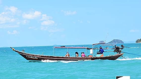 Traditional longtail boat on turquoise water off Koh Samui in May
