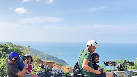 Pilotes de quad à un point de vue dans les collines de Koh Samui, surplombant la mer