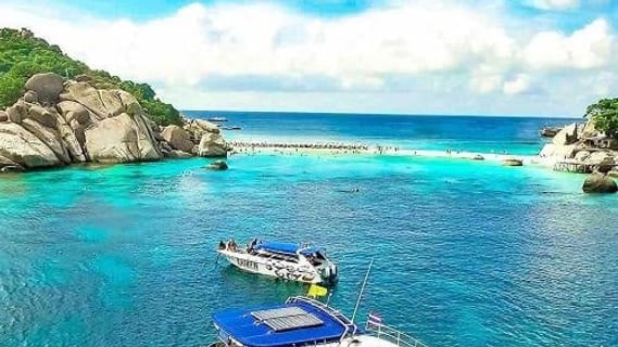 Tour boats over a turquoise reef during a snorkelling trip off Koh Samui