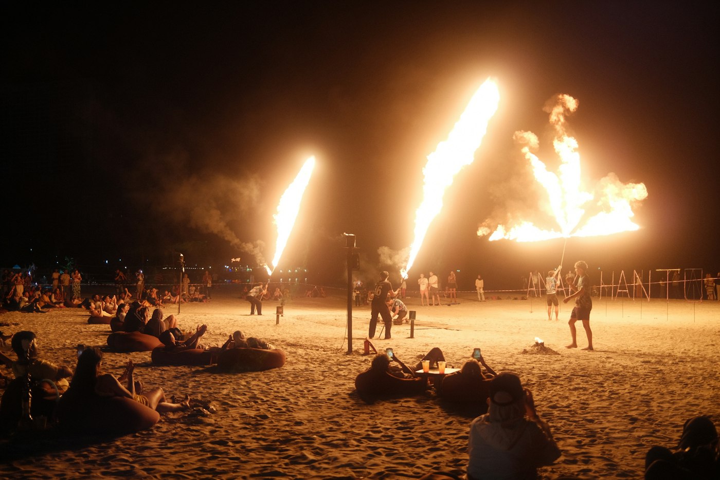 Spectacle de feu et foule sur la plage la nuit